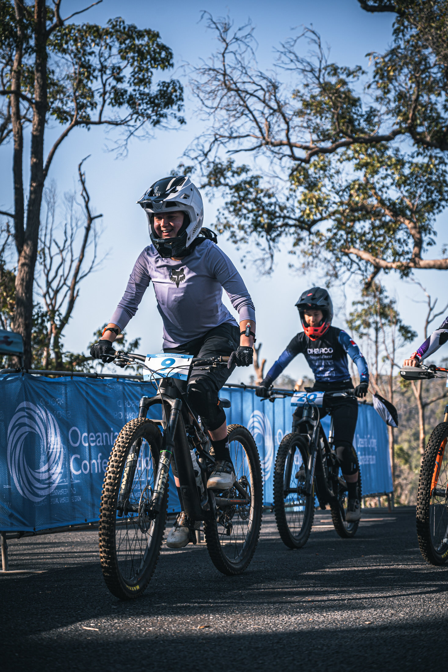 Two enduro riders smiling while on a liaison climb at the Oceania Champs in Collie