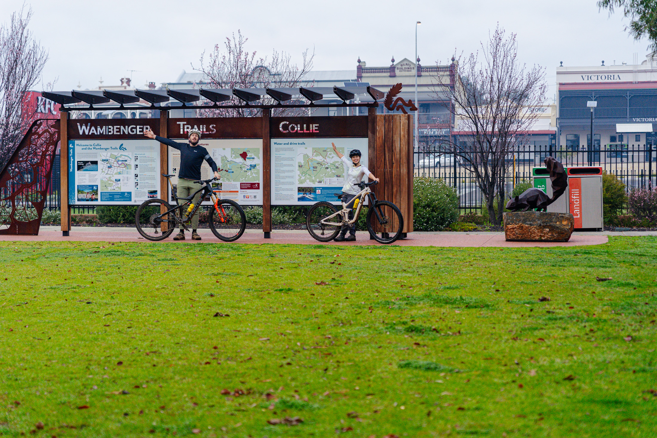 Two mountain bikers in front of the Wellington Dam mountain bike trails map in Collie, WA