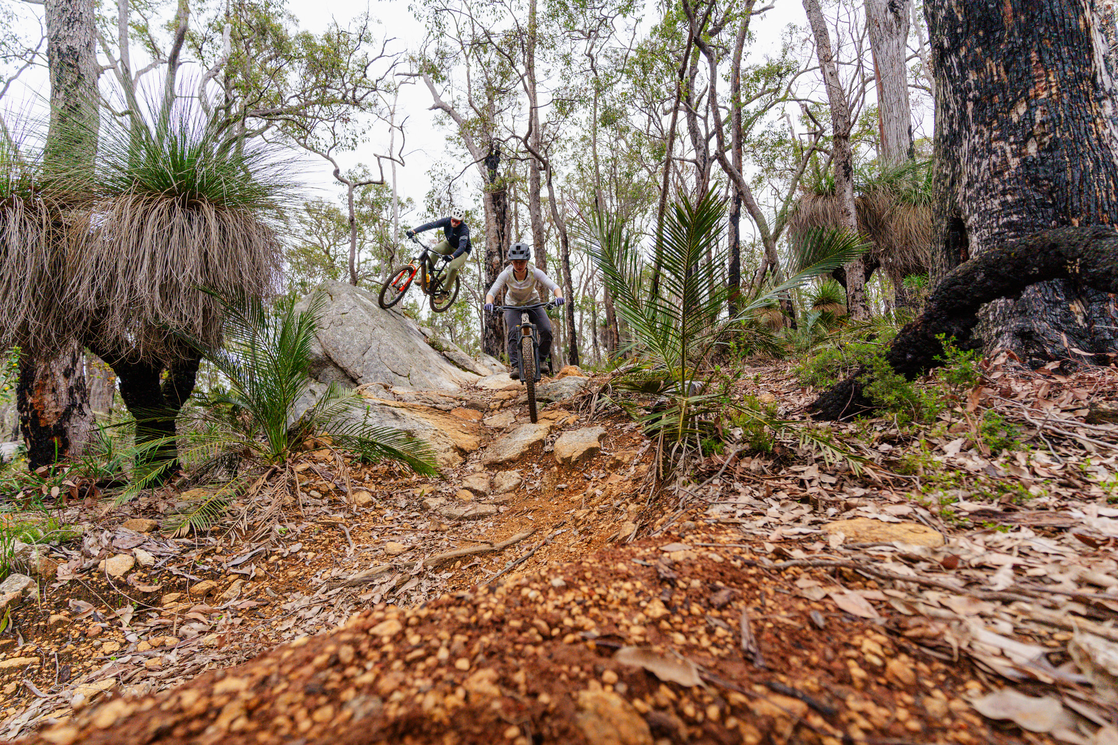 Two mountain bike riders demonstrating dual lines on a rocky trail in Collie, WA